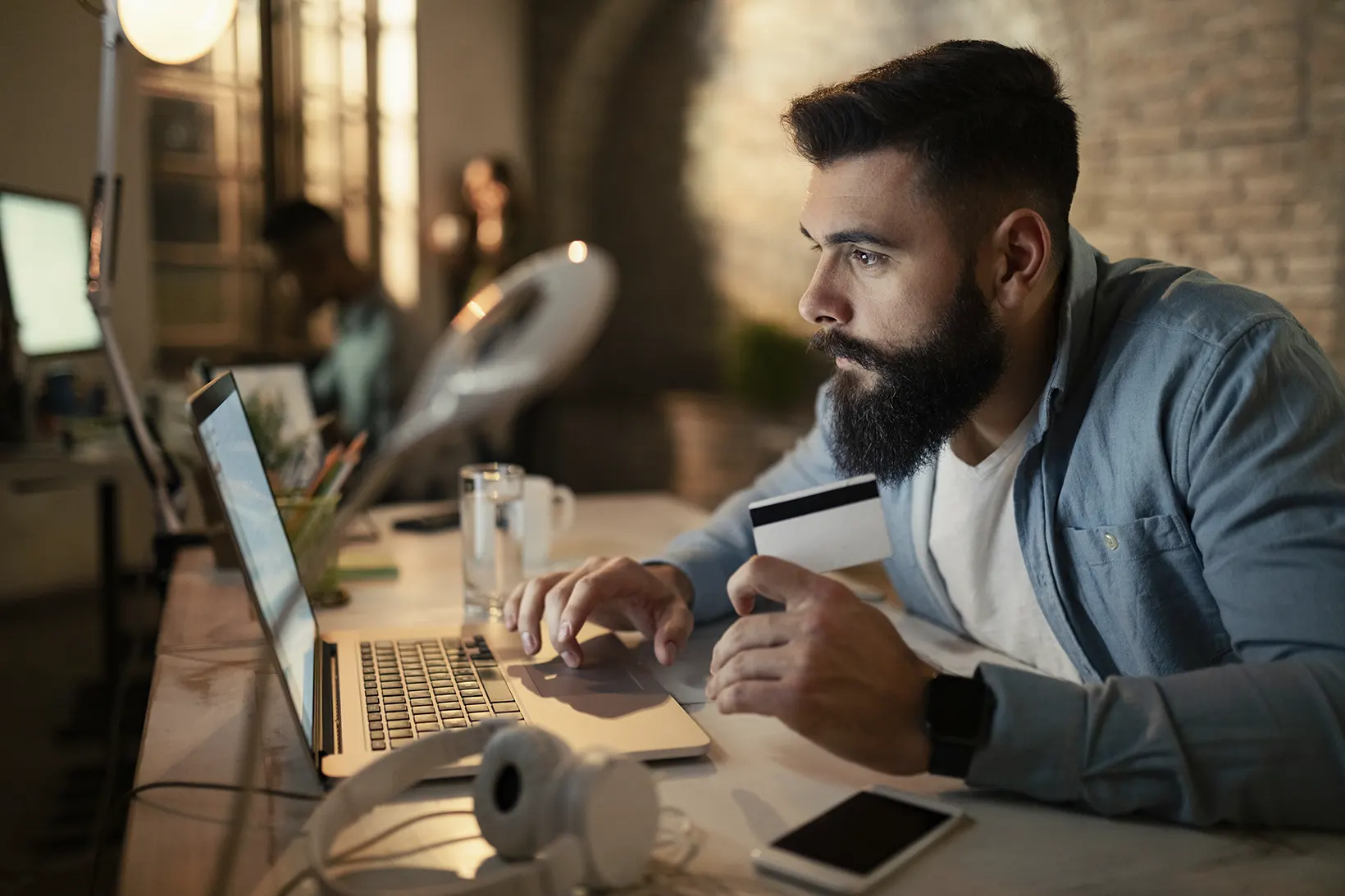Emprendedor Joven haciendo un pago con tarjeta en una laptop
